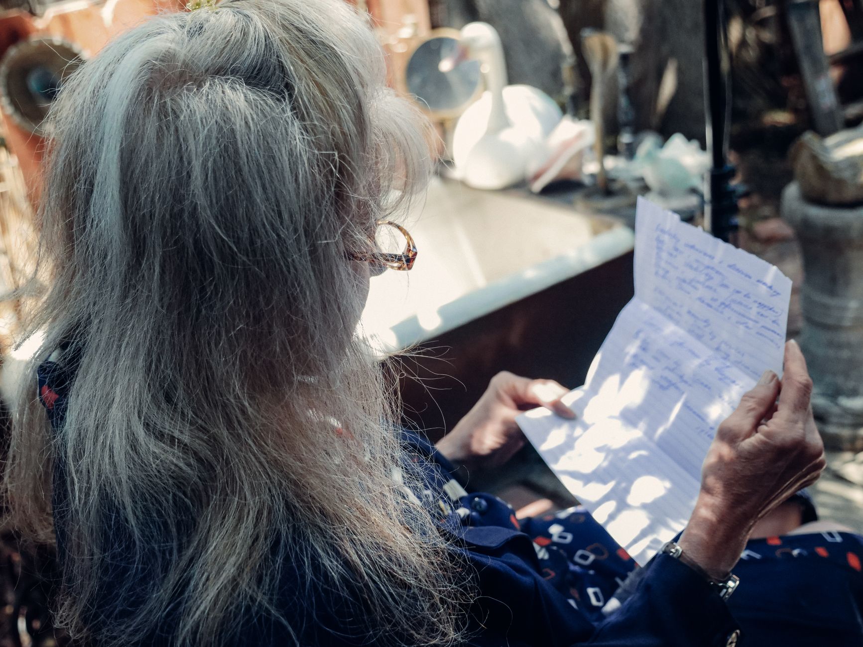 an elderly woman reading a letter